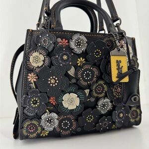 COACH 1941 Rogue 25 Tooled Leather Metal Tea
Rose appliqué & Purple Suede.